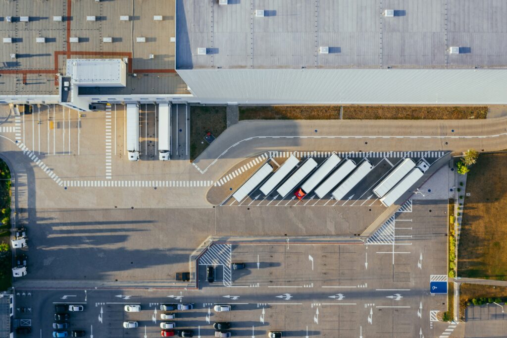 Aerial view of a warehouse parking lot with trucks lined up 